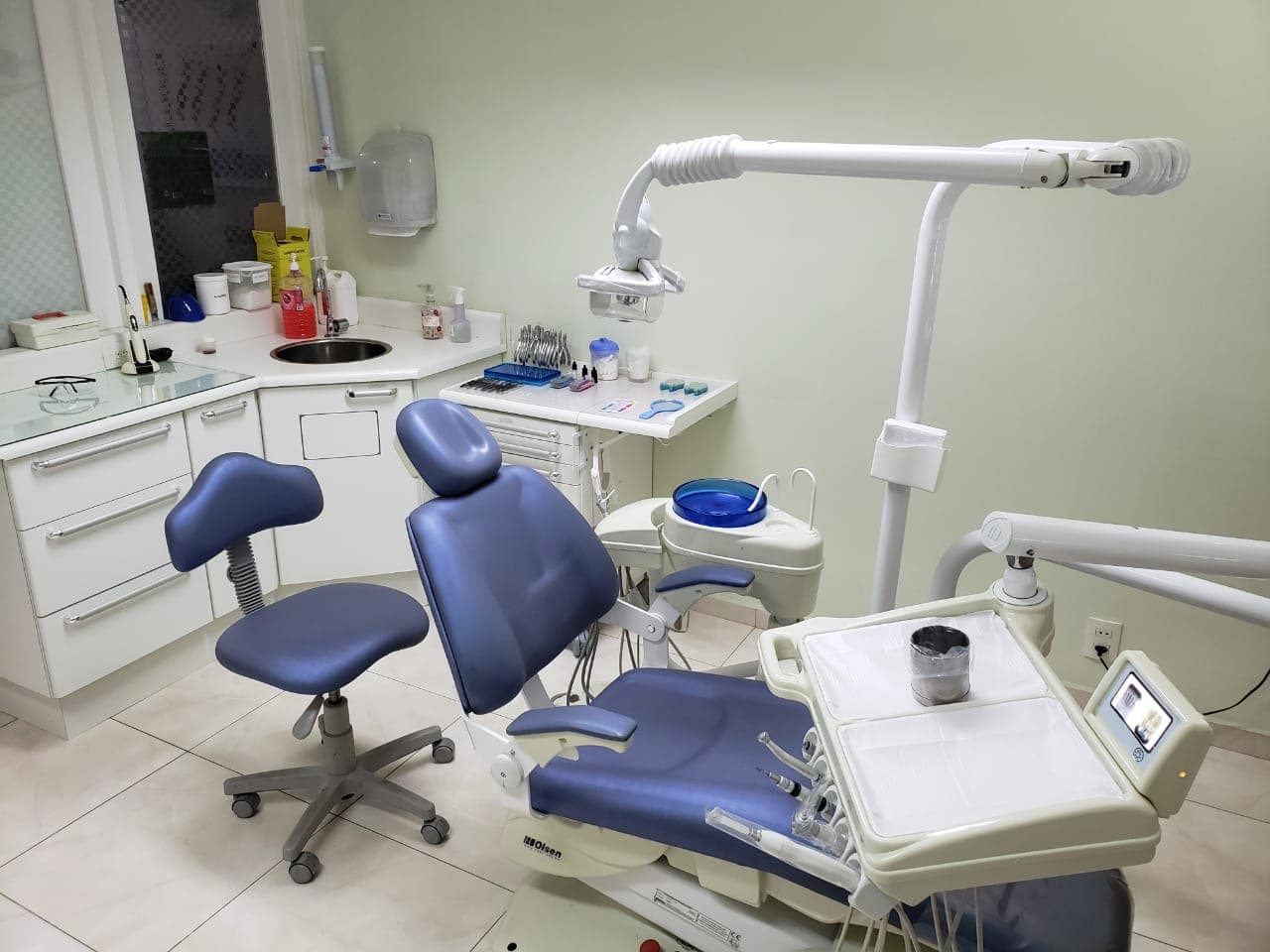 Cadeira odontológica lilás com mesa de instrumentos organizada