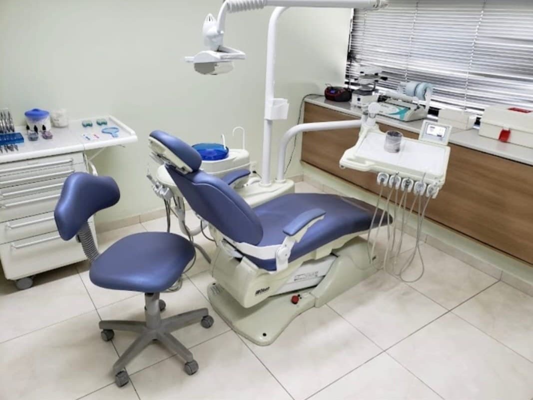 Consultório da Alô Dente com cadeira lilás e bancada de madeira sob a janela